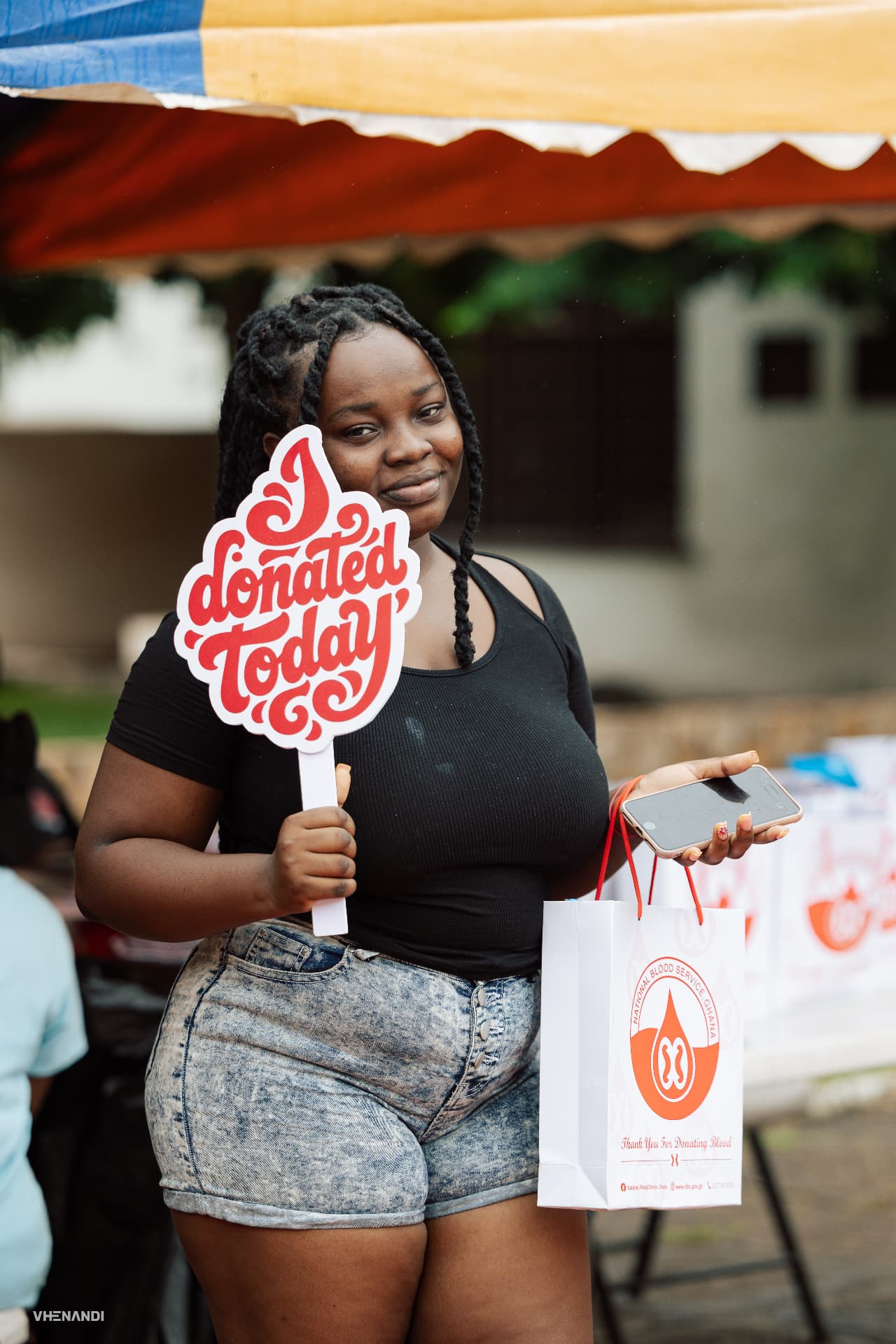 A donor holding an 'I donated today' sign and a thank-you bag