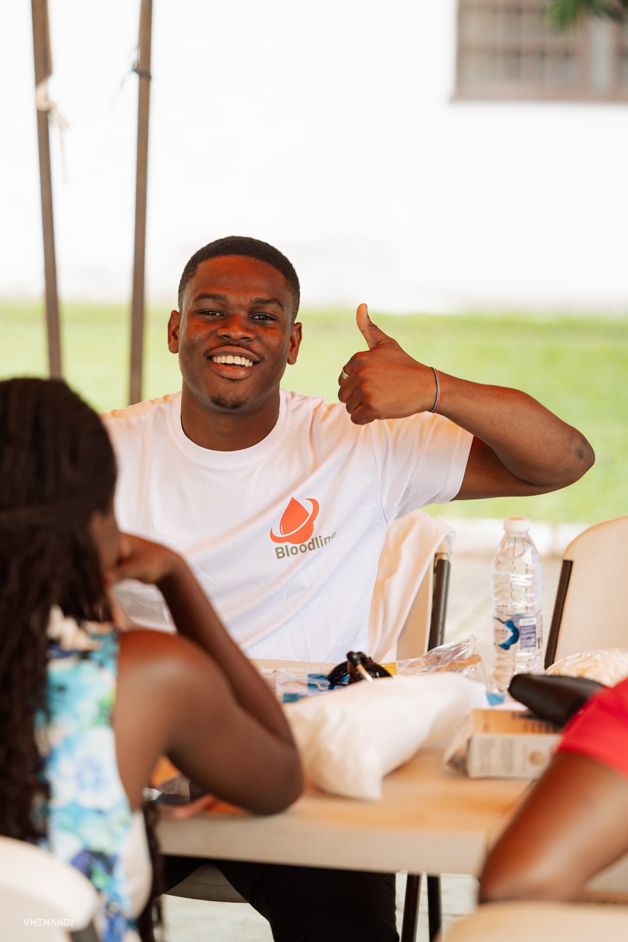 A Bloodline volunteer giving a thumbs-up at the donor registration desk