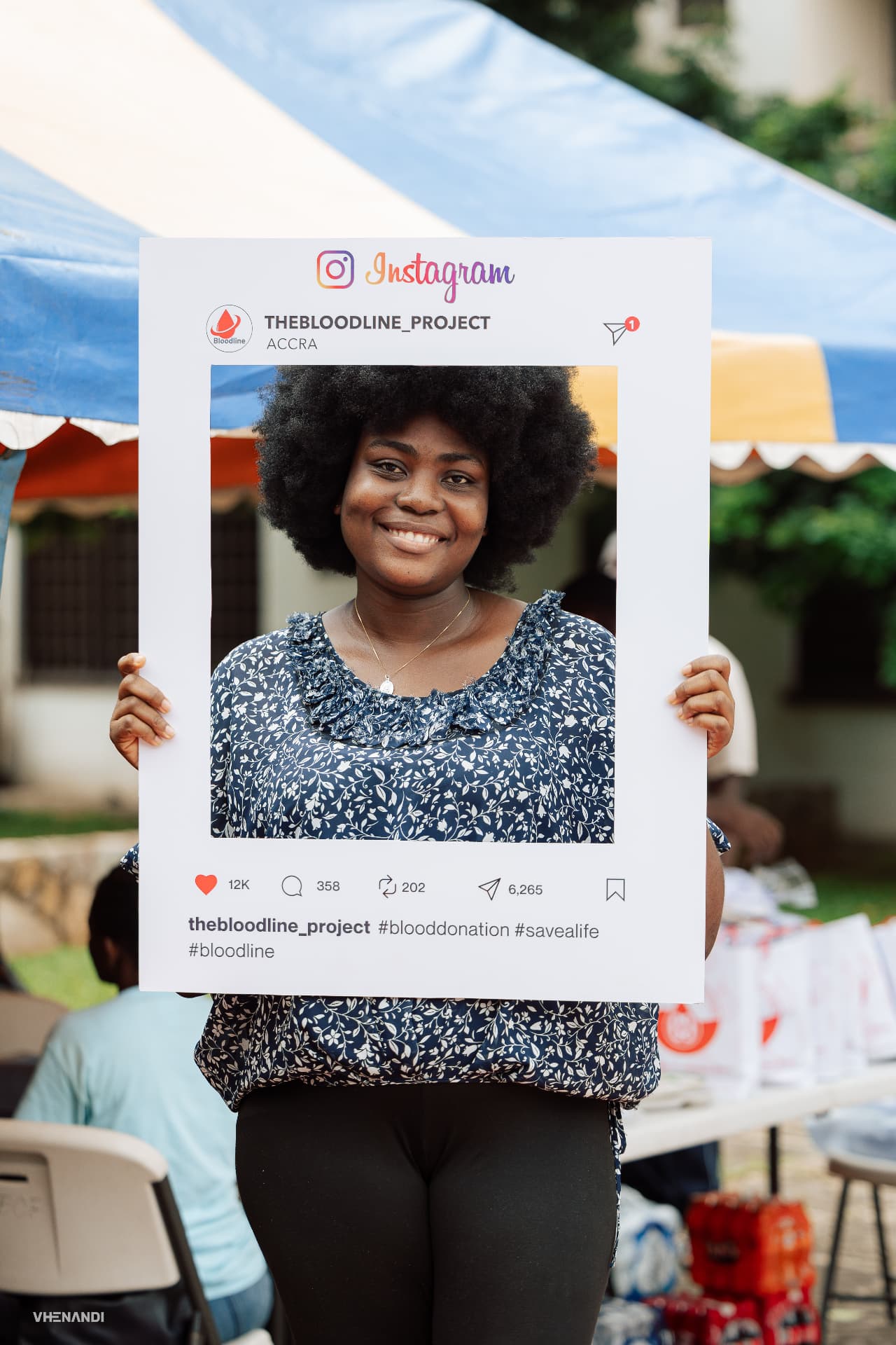 A donor posing with a Bloodline Instagram frame at the drive